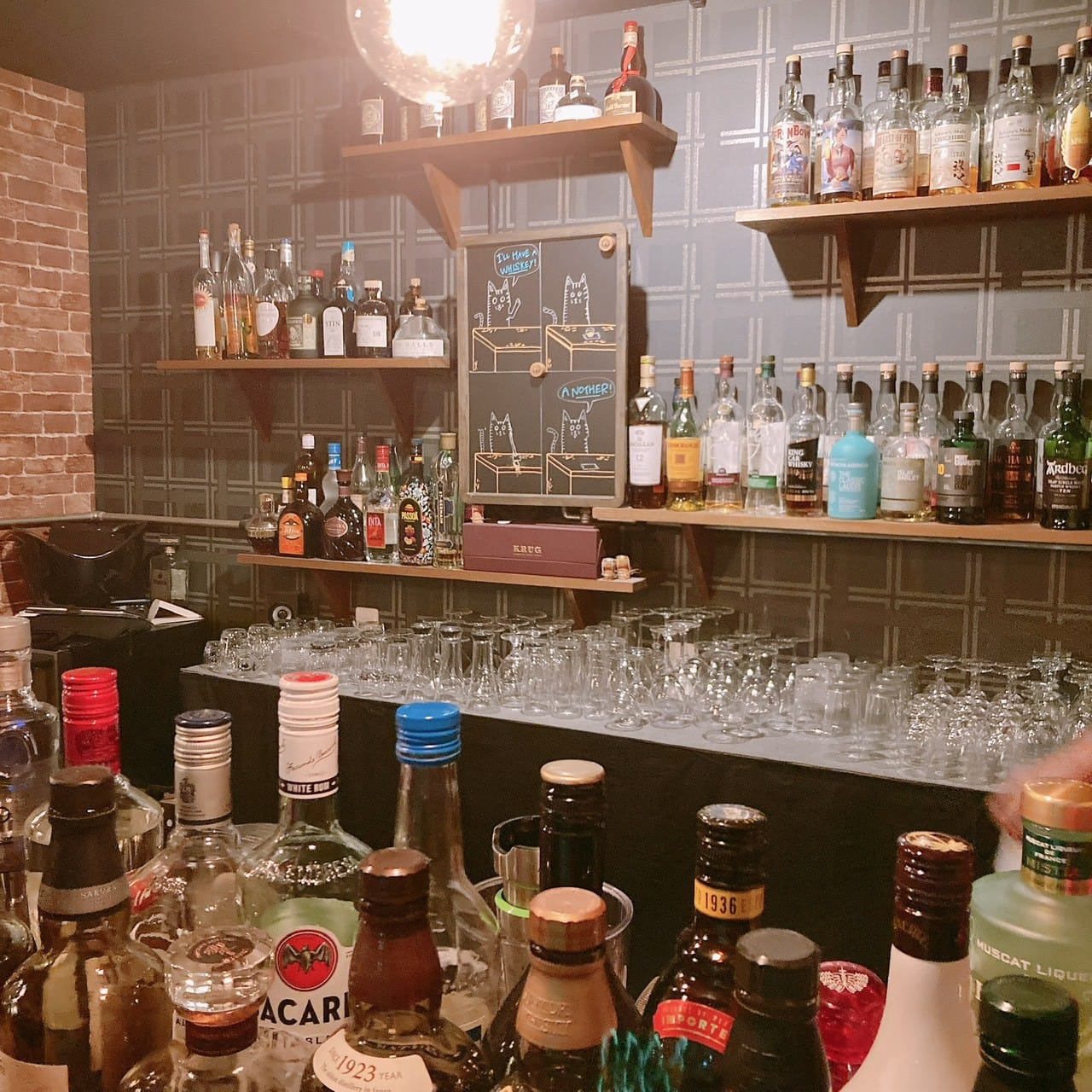 iKAZON its BAR の店内。カウンターの向こうの棚にウイスキーのボトルが並ぶ